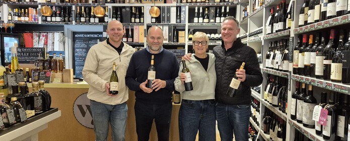 The wine reserve team holding wine in their shop